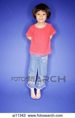 Young girl jumping, blue background View Large Photo Image Stock Image - Young girl jumping, blue background. Fotosearch