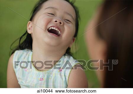 Young girl laughing, mother looking on View Large Photo Image Picture - Young girl laughing, mother looking on. Fotosearch