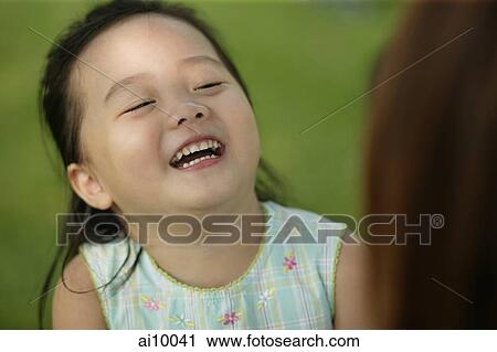 Young girl laughing, mother looking on View Large Photo Image Stock Image - Young girl laughing, mother looking on. Fotosearch