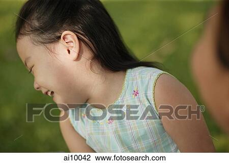 Young girl laughing, mother looking on View Large Photo Image Stock Image - Young girl laughing, mother looking on. Fotosearch