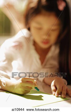 Picture - Young girl looking down, writing. Fotosearch