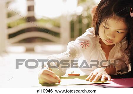 Young girl looking down, writing View Large Photo Image Stock Photograph - Young girl looking down, writing. Fotosearch