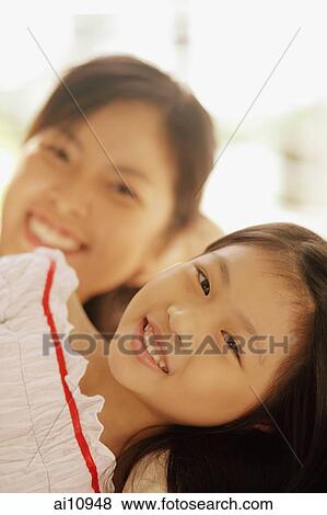 Young girl lying next to her mother, looking at camera View Large Photo Image Stock Photo - Young girl lying next to her mother, looking at camera. Fotosearch