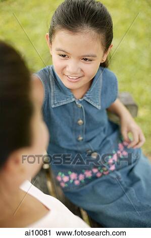Young girl sitting down with her mother View Large Photo Image Stock Image - Young girl sitting down with her mother. Fotosearch