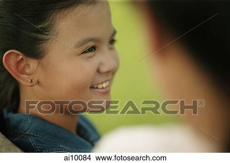 Young girl smiling, mother on foreground View Large Photo Image Picture - Young girl smiling, mother on foreground. Fotosearch