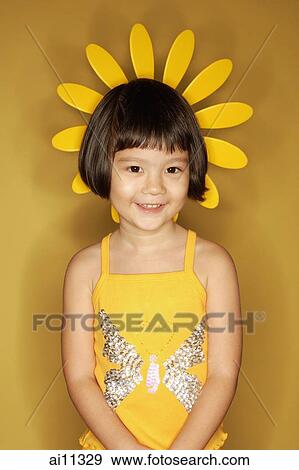 Young girl standing against yellow background View Large Photo Image Stock Photo - Young girl standing against yellow background. Fotosearch