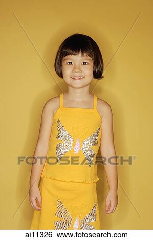 Young girl standing in front of yellow wall View Large Photo Image Stock Photograph - Young girl standing in front of yellow wall. Fotosearch