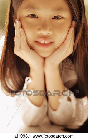 Young girl with hands on chin, looking at camera View Large Photo Image Stock Photo - Young girl with hands on chin, looking at camera. Fotosearch