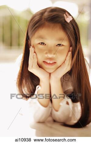Young girl with hands on chin, looking at camera View Large Photo Image Stock Photo - Young girl with hands on chin, looking at camera. Fotosearch