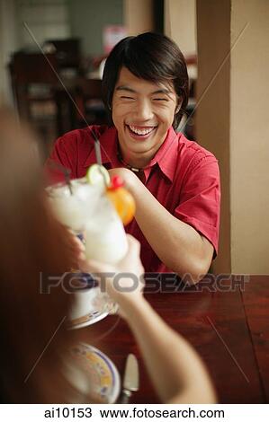 Young man and woman toasting with drinks View Large Photo Image Stock Image - Young man and woman toasting with drinks. Fotosearch