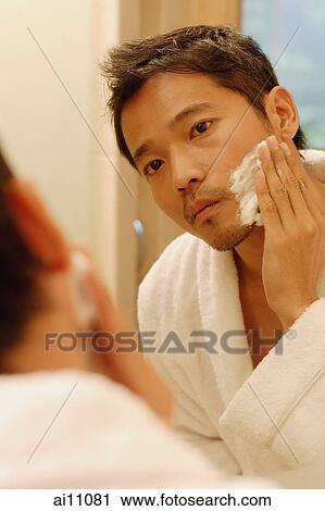 Young man applying shaving cream, looking in mirror View Large Photo Image Stock Image - Young man applying shaving cream, looking in mirror. Fotosearch
