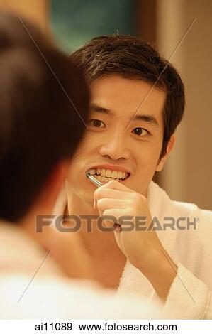 Young man brushing his teeth, looking in mirror View Large Photo Image Stock Photo - Young man brushing his teeth, looking in mirror. Fotosearch