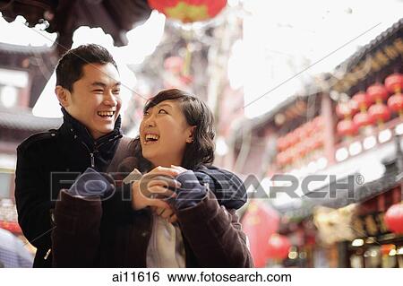 Young man embracing young woman, urban scene View Large Photo Image Stock Photograph - Young man embracing young woman, urban scene. Fotosearch