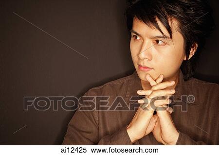 Young man, hands clasped, looking away, portrait View Large Photo Image Stock Photography - Young man, hands clasped, looking away, portrait. Fotosearch