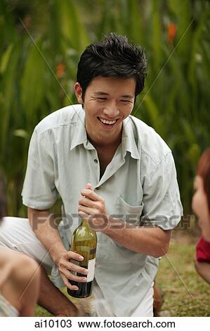 Young man holding bottle of wine View Large Photo Image Stock Image - Young man holding bottle of wine. Fotosearch