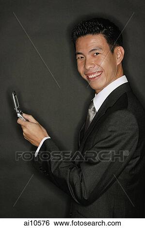 Young man holding mobile phone View Large Photo Image Stock Photograph - Young man holding mobile phone. Fotosearch