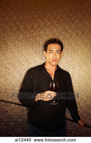 Young man, holding wine glass, looking away View Large Photo Image Stock Image - Young man, holding wine glass, looking away. Fotosearch