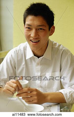 Stock Image - Young man in restaurant, portrait. Fotosearch