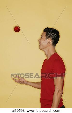 Young man juggling a ball, side view View Large Photo Image Stock Image - Young man juggling a ball, side view. Fotosearch