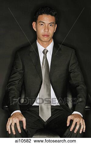 Young man looking at camera, hands on knees View Large Photo Image Stock Image - Young man looking at camera, hands on knees. Fotosearch
