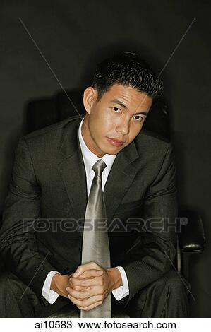 Young man looking at camera, hands clasped View Large Photo Image Stock Image - Young man looking at camera, hands clasped. Fotosearch