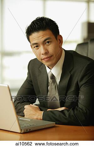 Young man looking at camera, laptop open on the table View Large Photo Image Stock Image - Young man looking at camera, laptop open on the table. Fotosearch