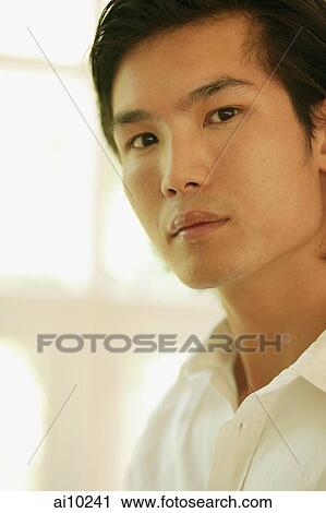 Stock Image - Young man looking at camera. Fotosearch