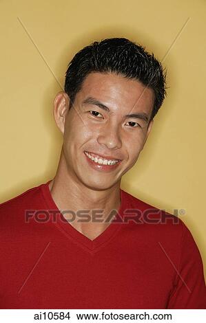 Young man looking at camera, yellow background View Large Photo Image Picture - Young man looking at camera, yellow background. Fotosearch
