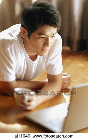 Young man looking at laptop, View Large Photo Image Stock Photograph - Young man looking at laptop,. Fotosearch