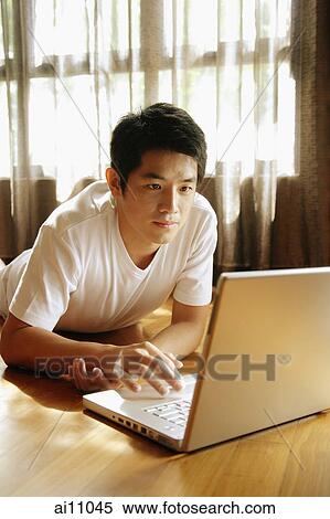 Young man looking at laptop. View Large Photo Image Stock Photography - Young man looking at laptop.. Fotosearch