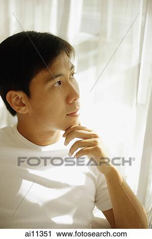 Young man looking away, hand on chin View Large Photo Image Stock Image - Young man looking away, hand on chin. Fotosearch