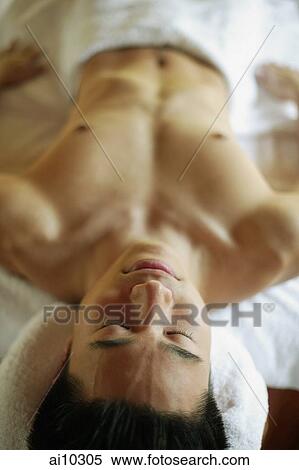 Young man lying down on massage table View Large Photo Image Stock Photography - Young man lying down on massage table. Fotosearch
