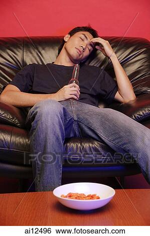 Young man on soda, holding beer bottle, eyes closed View Large Photo Image Stock Photograph - Young man on soda, holding beer bottle, eyes closed. Fotosearch