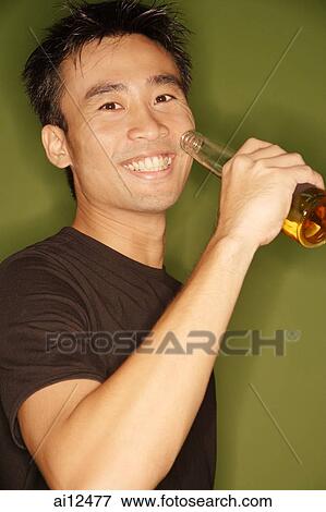 Young man raising beer bottle View Large Photo Image Stock Photo - Young man raising beer bottle. Fotosearch