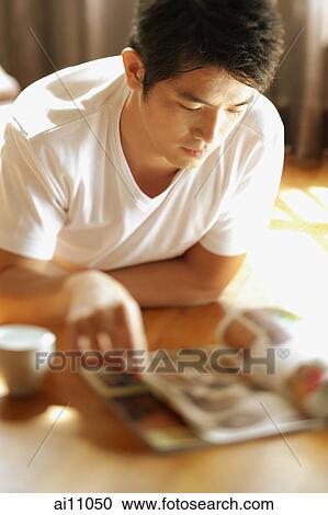 Young man reading magazine View Large Photo Image Stock Image - Young man reading magazine. Fotosearch