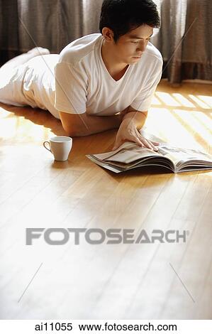 Young man reading magazine View Large Photo Image Stock Photography - Young man reading magazine. Fotosearch