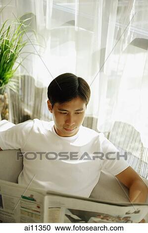 Young man reading newspaper View Large Photo Image Stock Image - Young man reading newspaper. Fotosearch