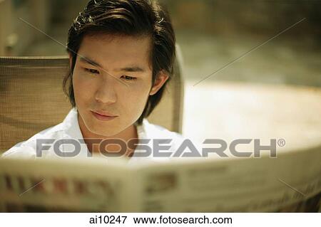 Stock Photo - Young man reading newspaper. Fotosearch