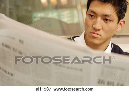 Young man reading newspaper View Large Photo Image Stock Photo - Young man reading newspaper. Fotosearch