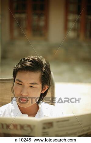 Young man reading newspaper View Large Photo Image Stock Photography - Young man reading newspaper. Fotosearch