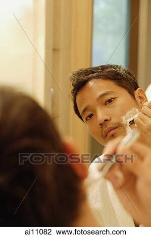 Young man shaving, looking in mirror View Large Photo Image Stock Image - Young man shaving, looking in mirror. Fotosearch
