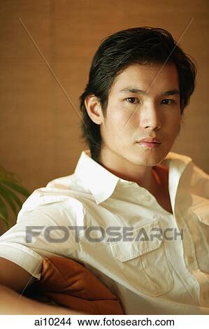 Young man sitting and looking at camera View Large Photo Image Picture - Young man sitting and looking at camera. Fotosearch