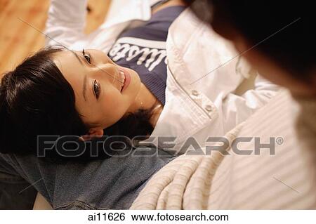 Young man sitting, young woman lying on his lap View Large Photo Image Stock Photograph - Young man sitting, young woman lying on his lap. Fotosearch