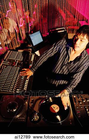 Young man spinning at club, high angle view View Large Photo Image Stock Photo - Young man spinning at club, high angle view. Fotosearch