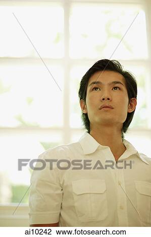 Young man standing and looking up. View Large Photo Image Stock Image - Young man standing and looking up.. Fotosearch
