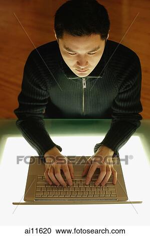 Young man using laptop, high angle view View Large Photo Image Stock Image - Young man using laptop, high angle view. Fotosearch