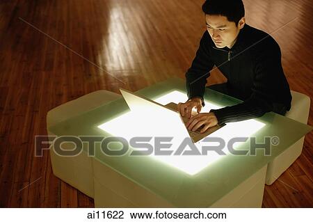 Young man using laptop on lightbox table View Large Photo Image Stock Image - Young man using laptop on lightbox table. Fotosearch
