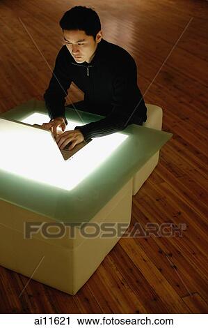 Young man using laptop, sitting at lightbox table View Large Photo Image Stock Image - Young man using laptop, sitting at lightbox table. Fotosearch