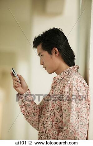 Young man using mobile phone View Large Photo Image Stock Image - Young man using mobile phone. Fotosearch