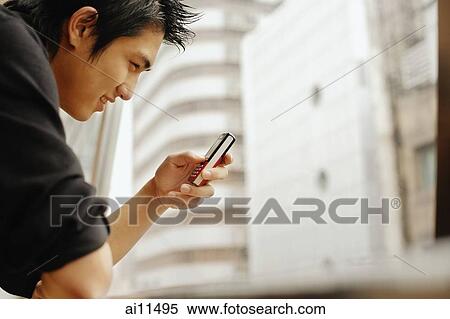 Stock Photography - Young man using mobile phone. Fotosearch